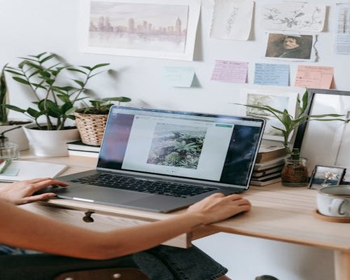 Person working on a modern laptop at a comfortable desk setup