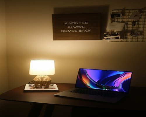 Cozy workspace details with warm lamp light and notebook